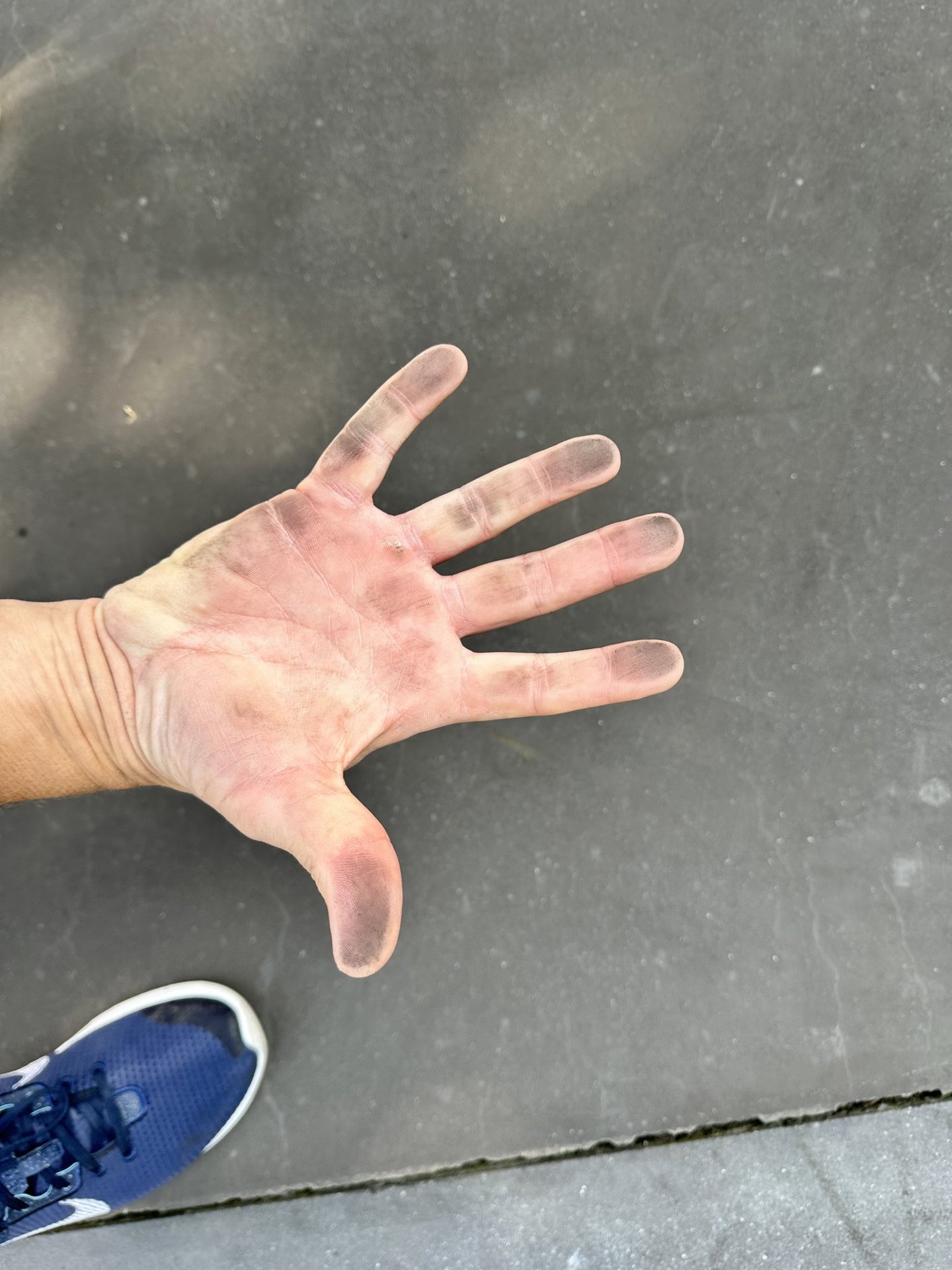 Hand with black pigment from coloured concrete